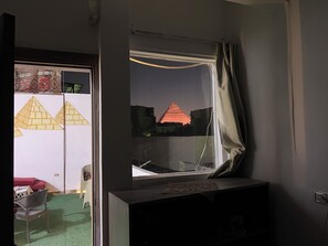 Una habitación con ventana que da a una estructura piramidal.
