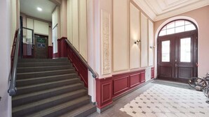 A grand staircase leading to a door with a bicycle parked nearby. - Comfortable Apartment in the Center | Close to Market Square and Railway Station (Wroclaw)
