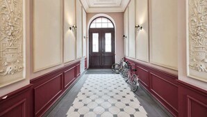 A hallway with a tiled floor, a bicycle rack, and decorative wall panels. - Comfortable Apartment in the Center | Close to Market Square and Railway Station (Wroclaw)