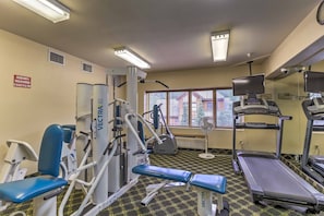 A gym with exercise equipment, a treadmill, and a window with blinds. - Keystone Condo Near Hiking, Biking & Fun (Keystone)