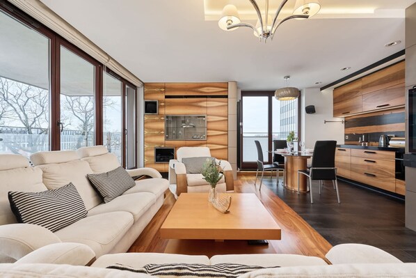 Una sala moderna con un sofá, una mesa de centro y una zona de comedor con sillas.
