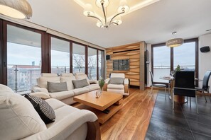 A modern living room with a sofa set, a coffee table, and a dining area with chairs.