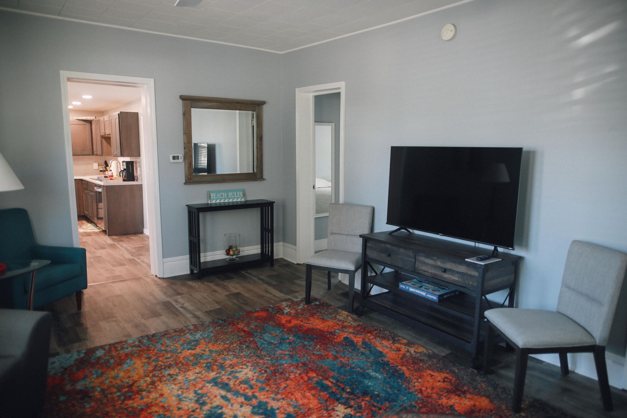 A living room with a TV, a fireplace, and a colorful rug.