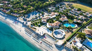 An aerial view of a coastal resort with a beach, multiple swimming pools, and a well-maintained landscape. - VOI Le Muse Essentia (Zambrone)