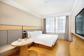 A modern hotel room with a large bed, bedside table, and a view of the city through large windows. - Ji Hotel (Chongqing)