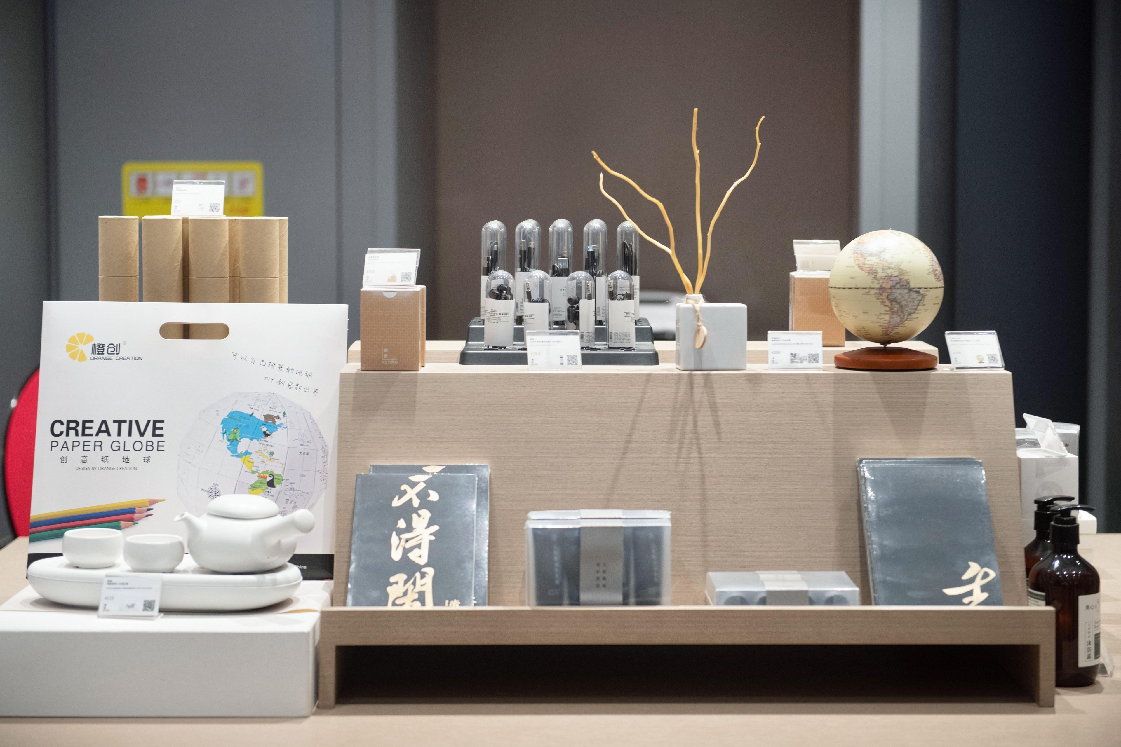 A display of various stationery items including a paper globe, a teapot, and several boxes.