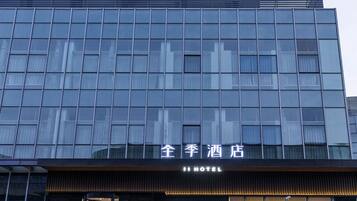 A modern hotel building with a reflective glass facade and a prominent sign indicating it is a hotel.