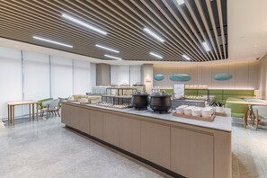 L'intérieur d'un café moderne, avec un comptoir central, un espace salon et des éléments décoratifs sur les murs.