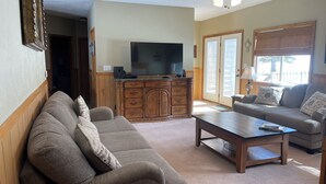 A living room with a sofa, a coffee table, a TV, and a cabinet. - Making Memories in Red River (Red River)