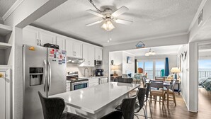A modern kitchen with a central island, stainless steel appliances, and a ceiling fan. - DL403 Tranquility Shore by First Flight Rentals (Nags Head)