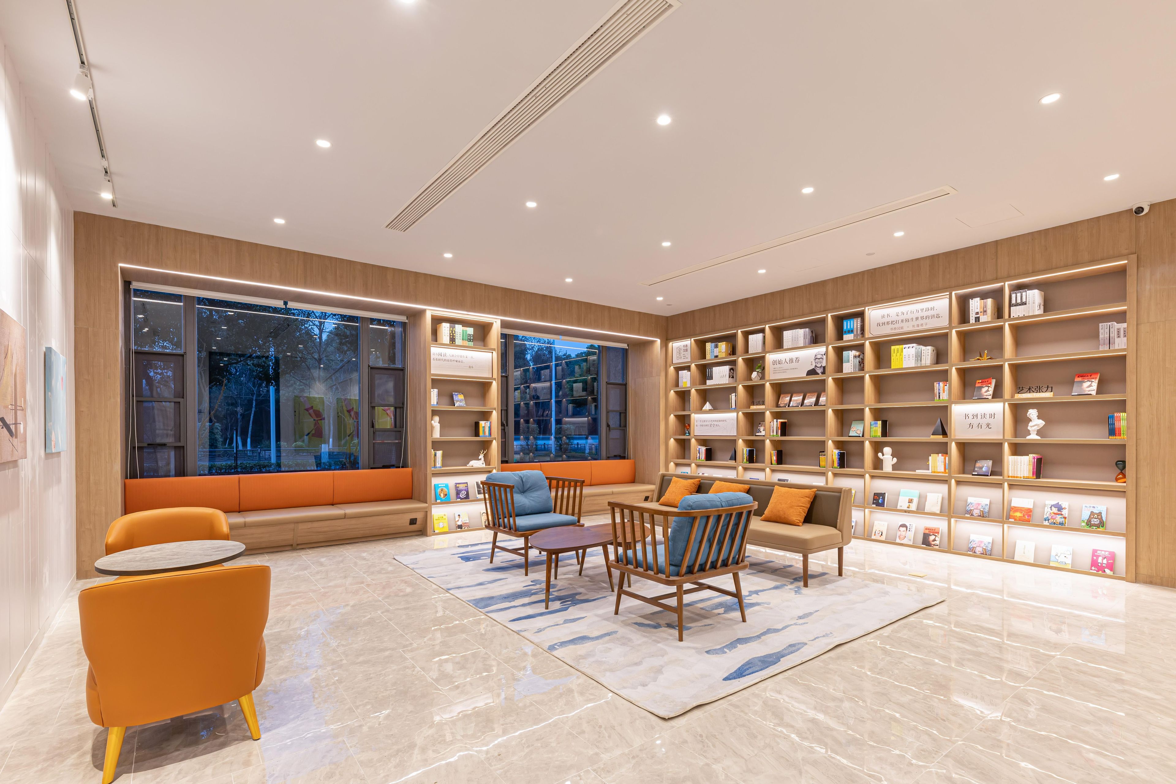 A modern library with bookshelves, seating, and a large window.