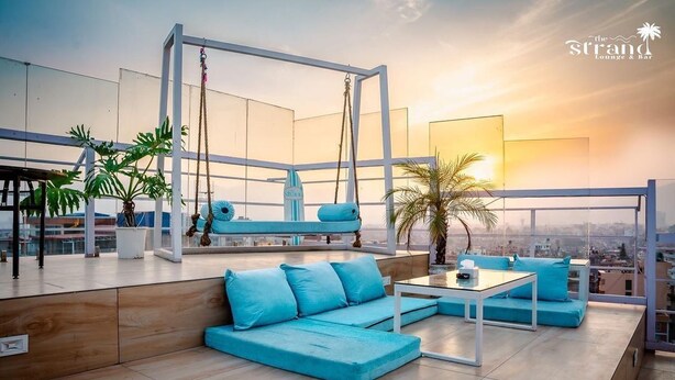 A rooftop lounge with a modern design, featuring a swing, seating areas, and potted plants. - Hotel Mirage Regency (Kathmandu)