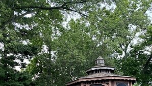 A gazebo with a wooden structure and a small porch, surrounded by a grassy yard and trees. - Yellow Springs Motel (Yellow Springs)