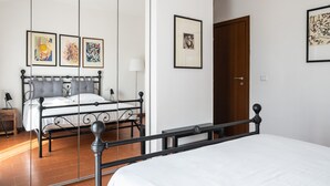 Une chambre à coucher avec un lit, une table de chevet, une lampe et une porte.