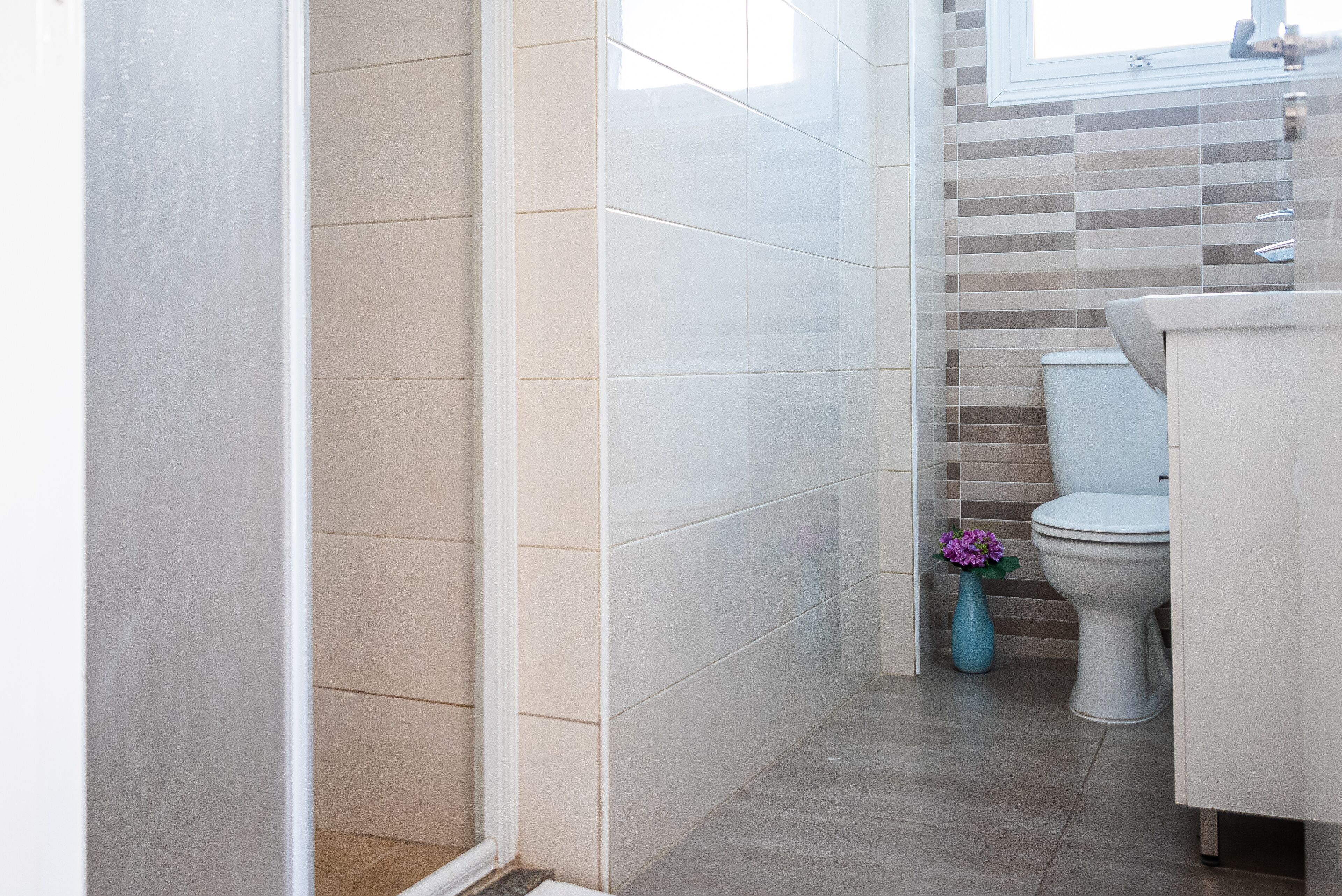 A bathroom with a shower, toilet, and sink.