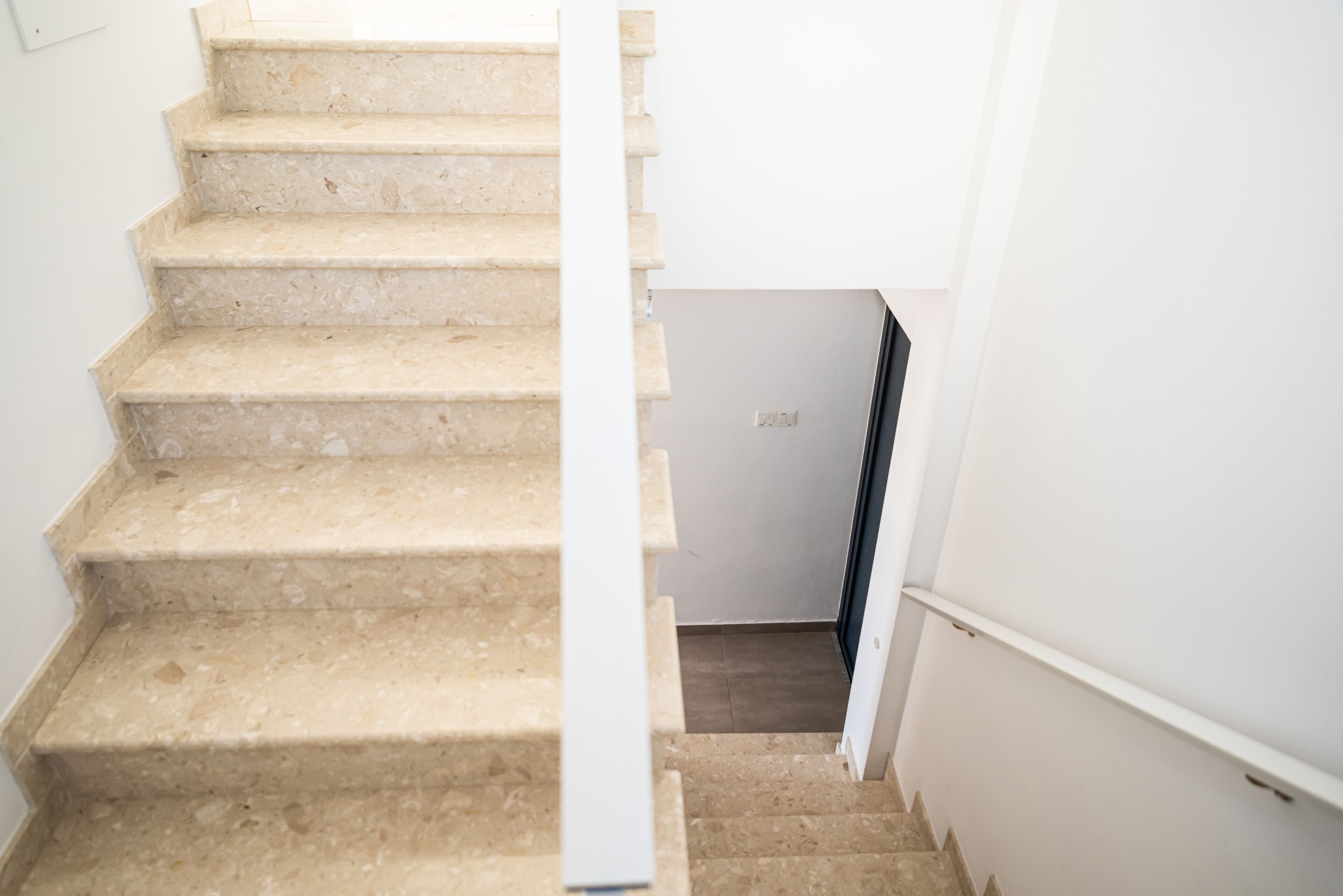A staircase with beige steps leading to a landing.