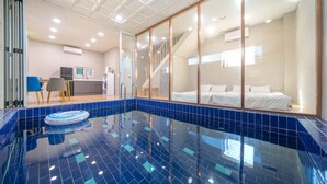A modern hotel room with a glass-enclosed balcony, a small kitchen area, and a separate bedroom with a bed and a bathroom. - Gapyeong Ddel Poolvilla (Gapyeong)
