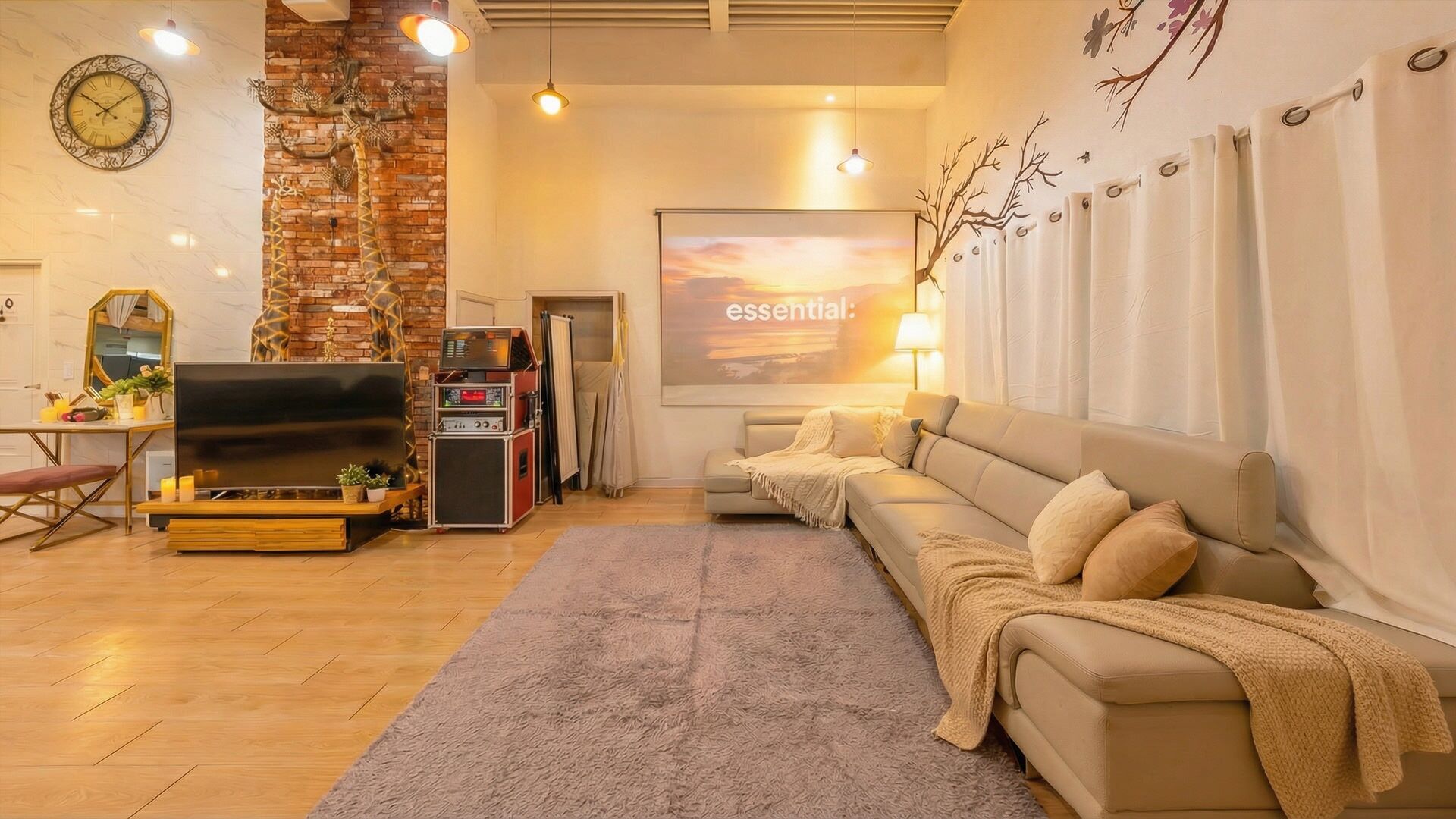 A living room with a flat-screen TV, a sofa, a coffee table, a brick accent wall, and a large painting.