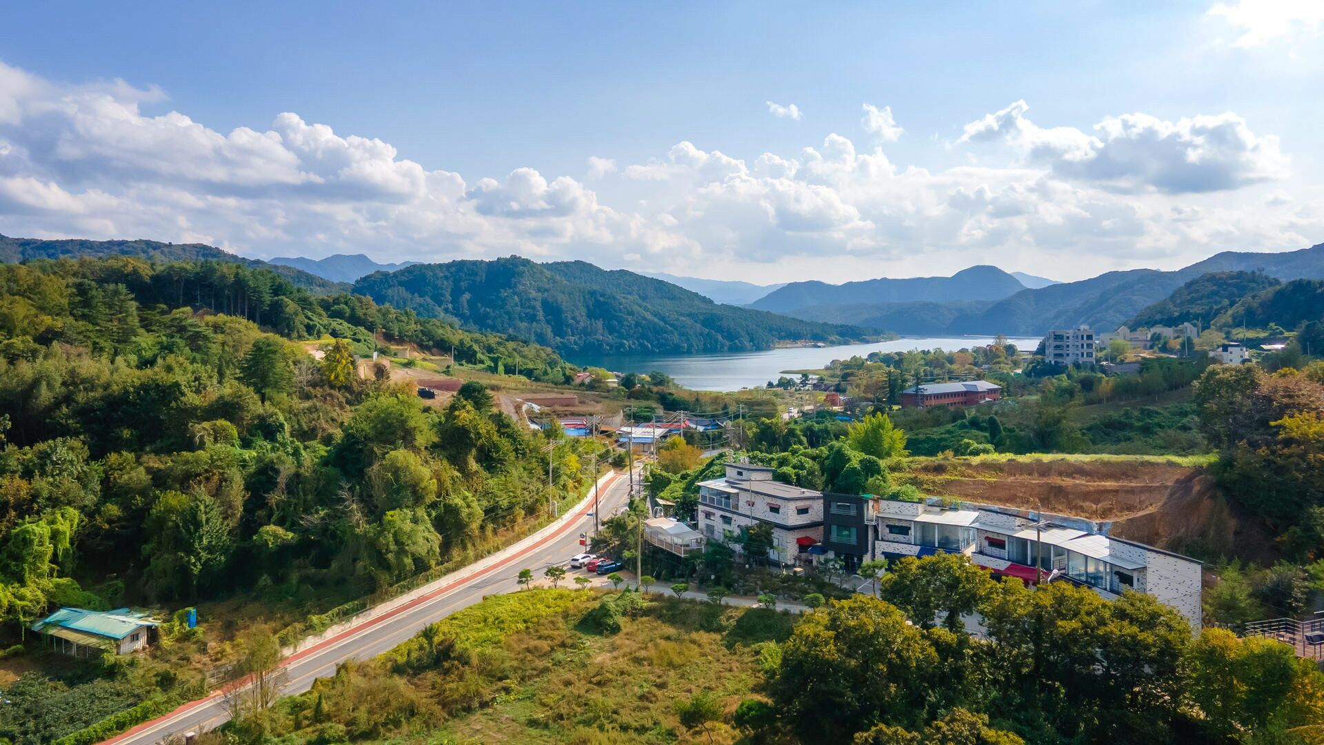 A coastal town with a road leading to a building complex.