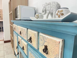 A blue dresser with decorative elements and a microwave on top. - Hotel Alandalus (Torrox)