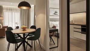 A modern dining area with a round table, black chairs, and a pendant light. - Hestia - Asklipiou 61 (Athens)