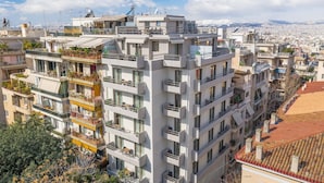 A multi-story residential building with balconies, large windows, and a view of a cityscape. - Hestia - Asklipiou 61 (Athens)