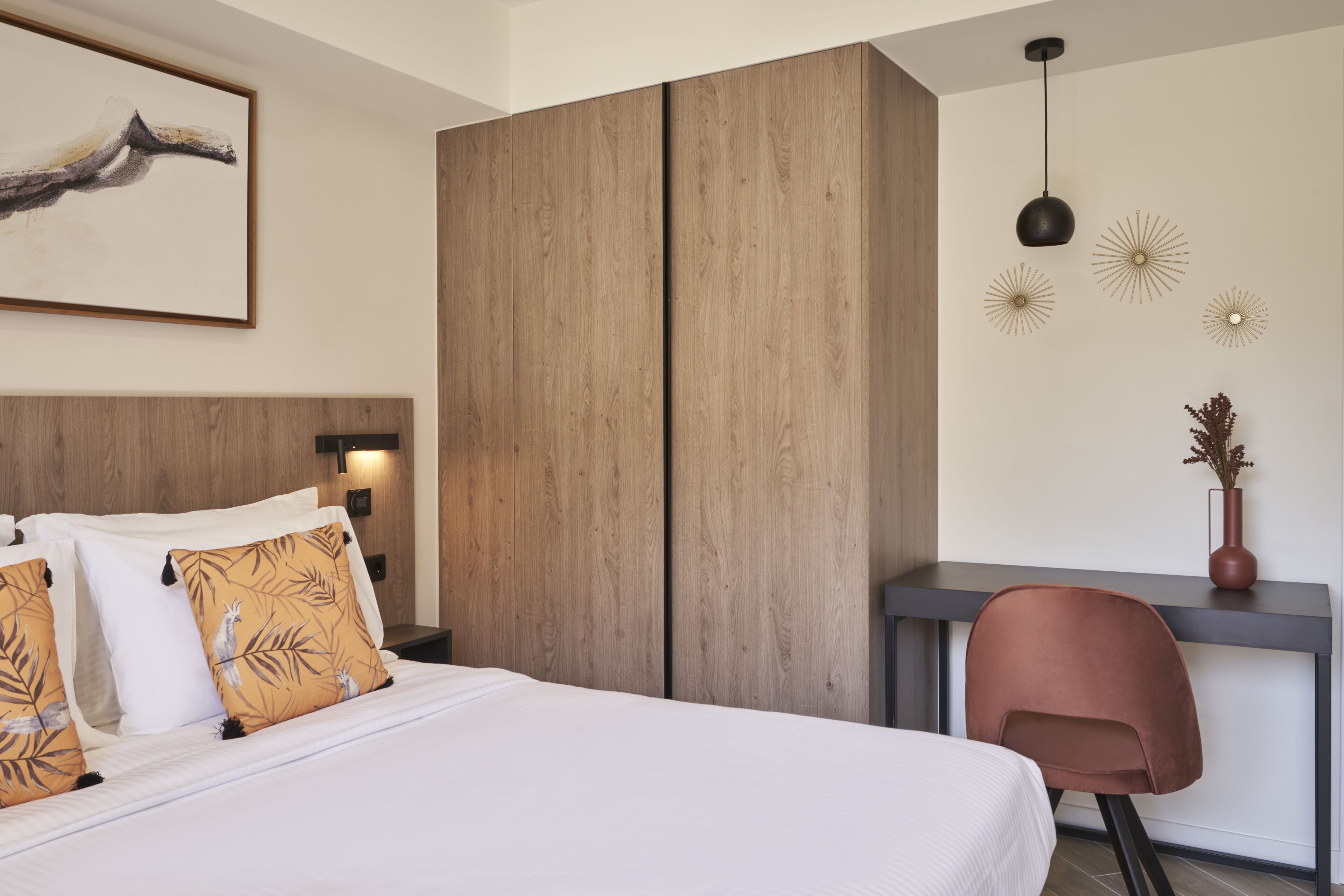 A modern hotel room with a large bed, a desk, and a chair.