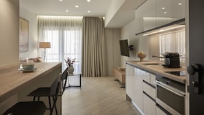 A modern kitchen with a wooden countertop, stainless steel appliances, and a dining area with a vase and chairs. - Hestia - Asklipiou 61 (Athens)