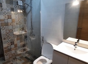 Chuveiro, toalhas de banho, sabonete, papel higiênico