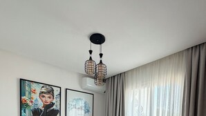 Un dormitorio con cama, mesita de noche, lámpara y dos unidades de aire acondicionado fijadas a la pared.