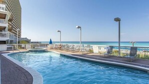 Ein Swimmingpool mit Liegestühlen und Blick auf den Ozean.