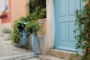 A blue bicycle parked on a cobblestone street next to a building with a blue door. - Rovinj City Studio - A1 with balcony for couples (Rovinj)