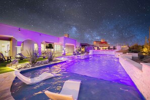 A swimming pool with a starry night sky above, surrounded by a building with purple lighting. - Hozho Tranquility w/ Slide, Pool & Commercial Golf Simulator (Scottsdale)