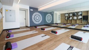 A yoga studio with mirrored walls, yoga mats, and exercise equipment.