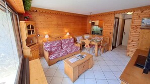 Un intérieur en bois comprenant un canapé, une table à manger et des placards.