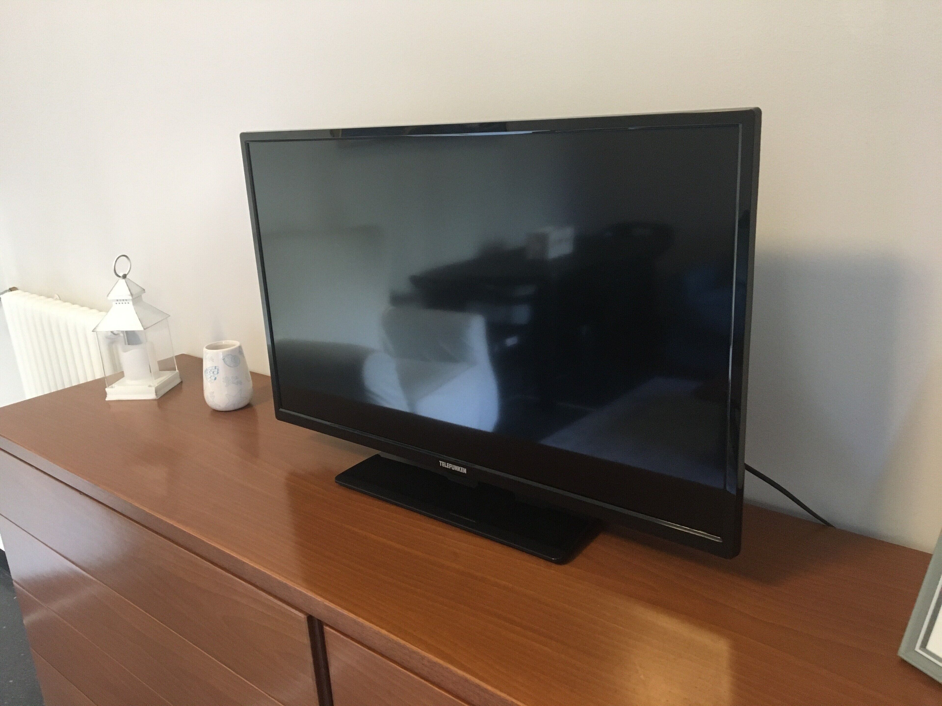 Een flatscreen televisie op een houten kast.