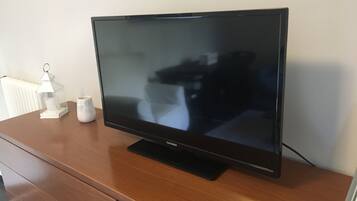 Een flatscreen televisie op een houten kast.