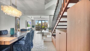 A modern kitchen with a wooden countertop, a hanging light fixture, and a view to the outside. - Rooftop Views, Private Beach Path & Resort Living in Palmas Del Mar (Humacao)