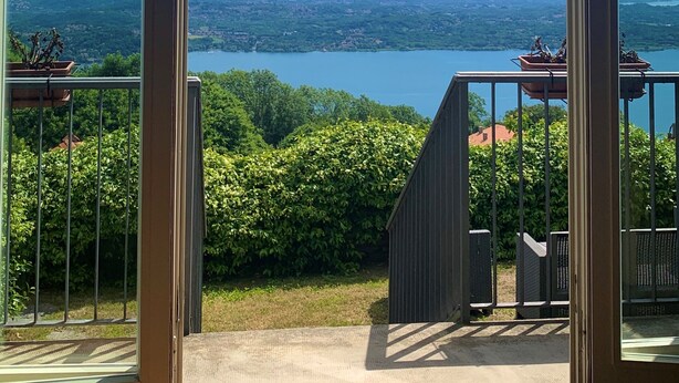A balcony with a view of a lake and mountains.
