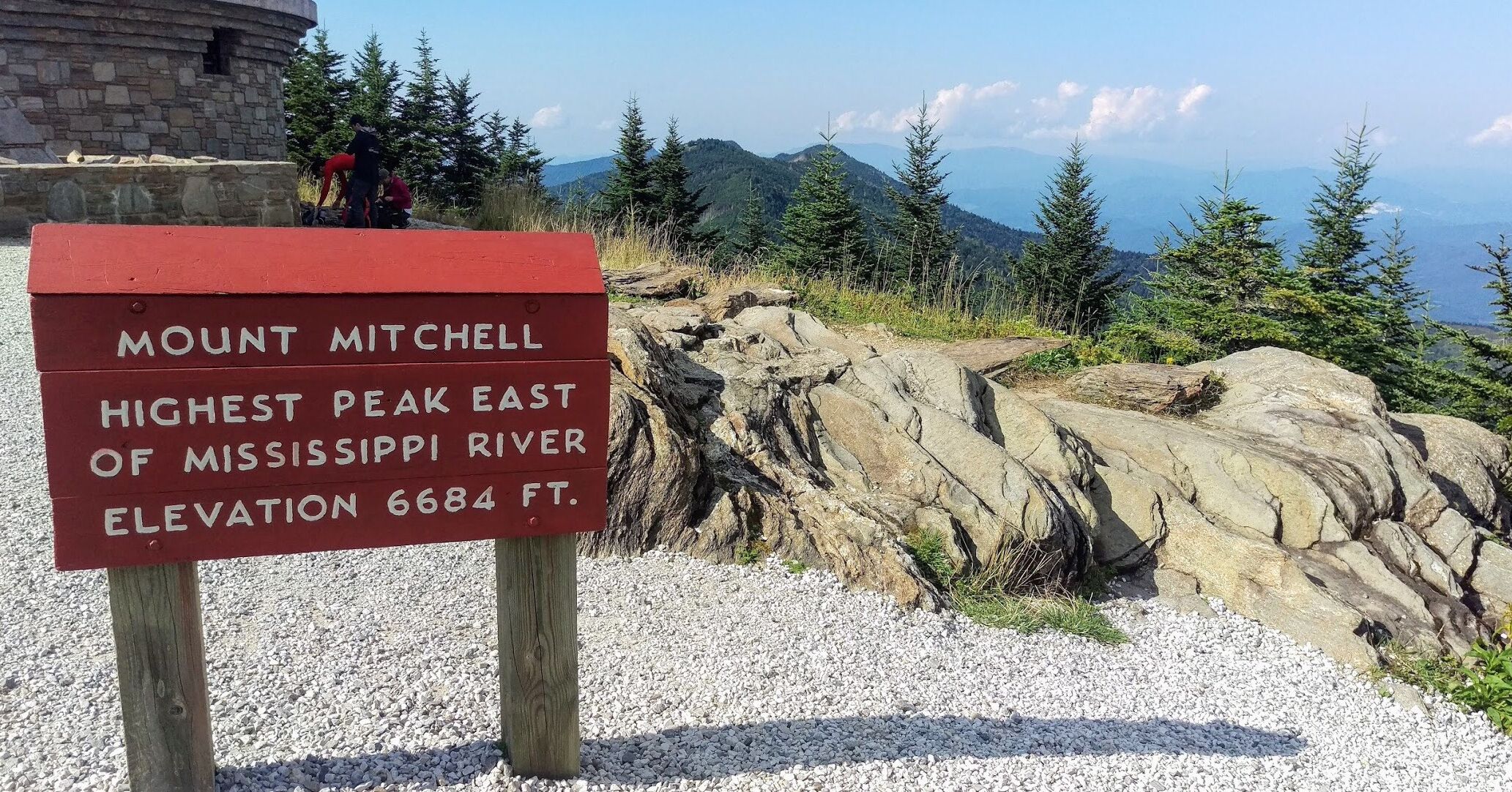 A sign indicating Mount Mitchell as the highest peak east of the Mississippi River with an elevation of 6684 ft.