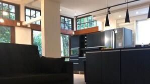 A modern kitchen with dark cabinetry, a central island, and pendant lighting. - Pedra Bonita Flats (Rio de Janeiro)