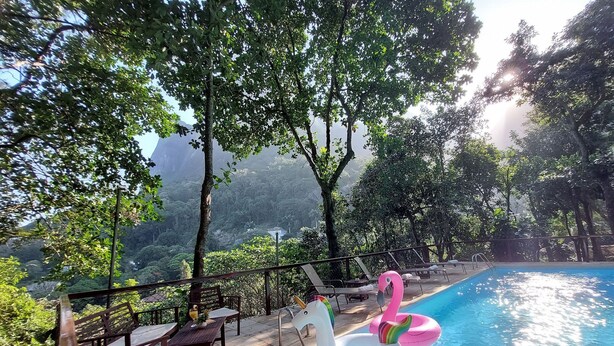 A pool area with lounge chairs and a flamingo float. - Pedra Bonita Flats (Rio de Janeiro)