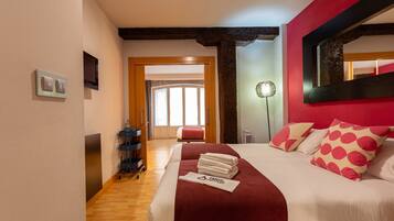 Una habitación de hotel con cama, televisión, escritorio y baño.