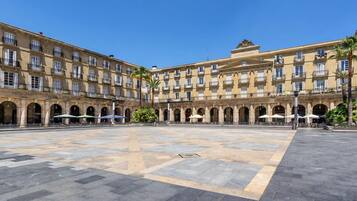 A spacious courtyard with a large open area and a building with multiple floors and balconies.