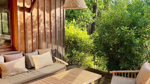 A wooden deck with a sofa, chairs, and a table. - WOODEN HOUSE TYPICAL OF THE BASIN (Lège-Cap-Ferret)