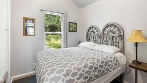 A bedroom with a bed, a window with curtains, a bedside lamp, and a wall-mounted clock. - Tiny Home@ Mt Rainier-Hot tub-AC (Ashford)