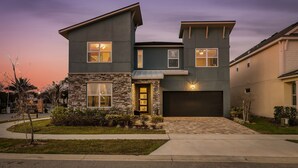 A modern two-story house with a stone facade, a garage, and a well-maintained lawn. - “Magical Memories Manor” - Awesome Movie and Game Rooms (Kissimmee)