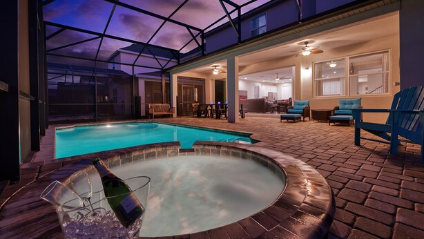 A covered outdoor area with a swimming pool, hot tub, and seating area. - “Magical Memories Manor” - Awesome Movie and Game Rooms (Kissimmee)
