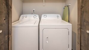 A laundry room with two white front-loading washing machines and a drying rack. - Middle Of Town Center, Luxury Two Bedroom Condo (Big Sky)