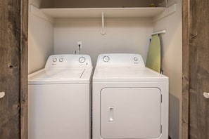 Een wasserette met twee witte voorladers en een droogrek.